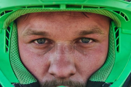 Photo for The determined face of a professional motocross rider, adorned with a protective helmet, reflects unwavering focus and readiness for an adrenaline-fueled adventure - Royalty Free Image