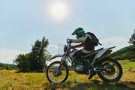 Téléchargez les photos : Un motocycliste équipé de matériel professionnel, fait du motocross sur des prairies périlleuses, s'entraîne pour une compétition à venir - en image libre de droit