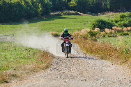 Téléchargez les photos : Un motocross professionnel sur un sentier forestier perfide et exaltant en moto - en image libre de droit