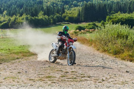 Foto de Un ciclista profesional de motocross montando un emocionante sendero forestal todoterreno traicionero en su motocicleta - Imagen libre de derechos