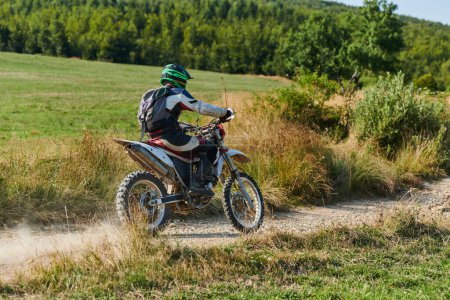 Téléchargez les photos : Un motocross professionnel sur un sentier forestier perfide et exaltant en moto - en image libre de droit