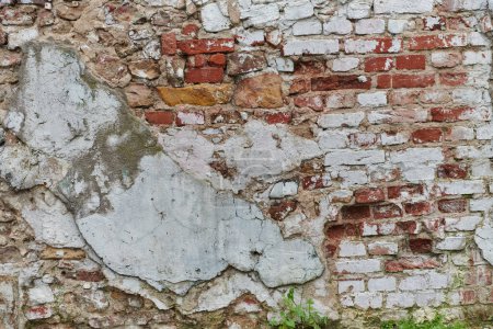 Photo for A weathered and aged stone brick wall, showing signs of decay and history, stands as a testament to time and wear. - Royalty Free Image