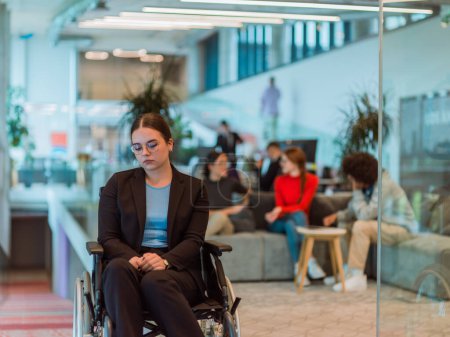 Téléchargez les photos : Dans un bureau moderne, une jeune femme d'affaires en fauteuil roulant est entourée de ses collègues de soutien, incarnant l'esprit d'inclusion et de diversité au travail.. - en image libre de droit