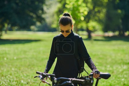 Photo for In the radiant embrace of a sunny day, a joyous girl, adorned in professional cycling gear, finds pure bliss and vitality as she cruises through the park on her bicycle, her infectious laughter - Royalty Free Image