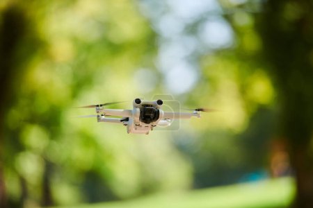 Téléchargez les photos : Drone professionnel filmant le parc par une journée ensoleillée. - en image libre de droit