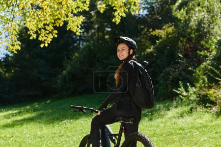 Foto de En el abrazo radiante de un día soleado, una chica alegre, adornada con equipo de ciclismo profesional, encuentra pura felicidad y vitalidad mientras cruza por el parque en su bicicleta, su risa infecciosa - Imagen libre de derechos