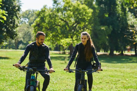 Photo for A blissful couple, adorned in professional cycling gear, enjoys a romantic bicycle ride through a park, surrounded by modern natural attractions, radiating love and happiness. - Royalty Free Image