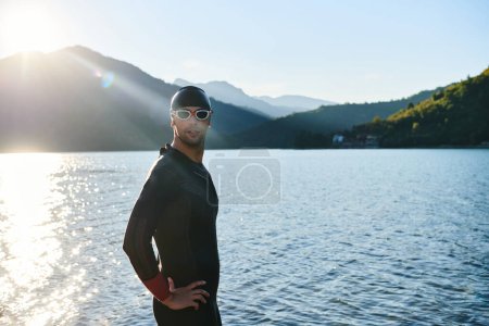 Foto de Auténtico atleta de triatlón preparándose para el entrenamiento de natación en el lago. Foto de alta calidad - Imagen libre de derechos