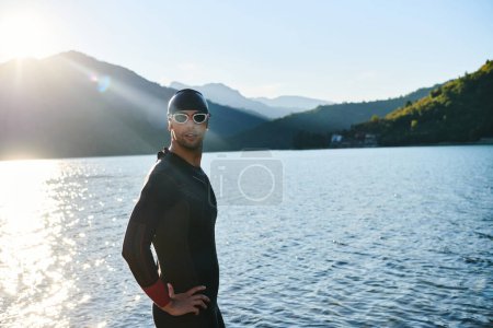 Photo for Authentic triathlon athlete getting ready for swimming training on lake. High quality photo - Royalty Free Image