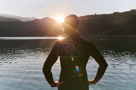 Foto de Auténtico atleta de triatlón preparándose para el entrenamiento de natación en el lago. Foto de alta calidad - Imagen libre de derechos