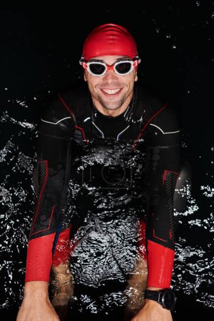 Photo for Authentic triathlete swimmer having a break during hard training on night. - Royalty Free Image