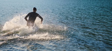 Téléchargez les photos : Athlète de triathlon commence l'entraînement de natation sur le lac. - en image libre de droit