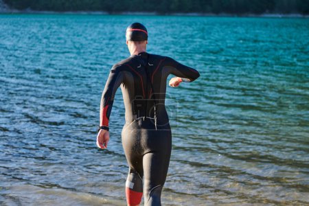 Téléchargez les photos : Athlète de triathlon commence l'entraînement de natation sur le lac. - en image libre de droit