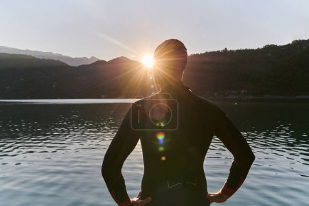 Photo for Authentic triathlon athlete getting ready for swimming training on lake. High quality photo - Royalty Free Image