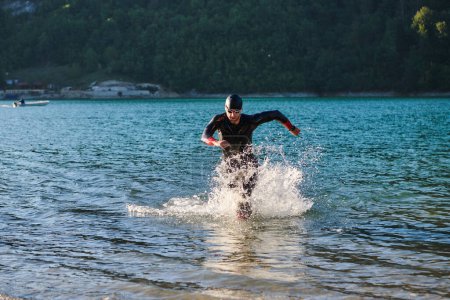 Photo for Triathlon athlete starting swimming training on lake. - Royalty Free Image
