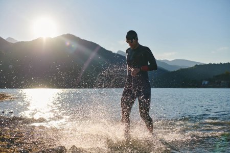 Foto de Atleta de triatlón comenzando a nadar entrenamiento en el lago. - Imagen libre de derechos