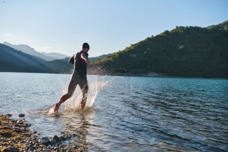 Photo for Triathlon athlete starting swimming training on lake. - Royalty Free Image