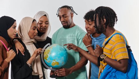 Téléchargez les photos : Un groupe diversifié d'étudiants est rassemblé autour d'un globe, absorbé dans l'exploration et l'étude, leur énergie vibrante capturée sur un fond blanc immaculé, symbolisant l'unité et la curiosité dans leur - en image libre de droit