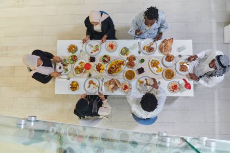 Téléchargez les photos : Vue d'ensemble de la famille musulmane traditionnelle et diversifiée se réunit pour partager un délicieux repas iftar pendant le mois sacré du Ramadan, incarnant l'essence de la joie familiale, la richesse culturelle, et - en image libre de droit