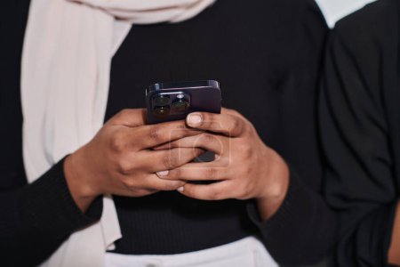 Photo for Captured in a close-up moment, a girl in hijab skillfully engages with her smartphone, reflecting a contemporary lifestyle where digital connectivity seamlessly intertwines with cultural expression - Royalty Free Image