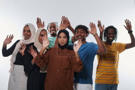 Foto de Un grupo alegre y diverso, incluyendo un hombre afroamericano y chicas que usan hiyab, exuberantemente saludan y celebran, encarnando la vitalidad de la vida estudiantil contra un fondo blanco, simbolizando - Imagen libre de derechos