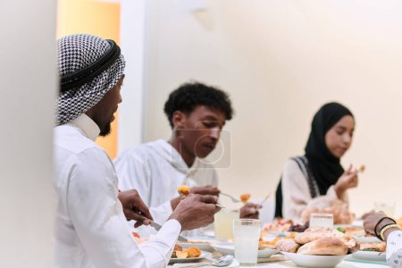 Photo for A traditional and diverse Muslim family comes together to share a delicious iftar meal during the sacred month of Ramadan, embodying the essence of familial joy, cultural richness, and spiritual unity - Royalty Free Image