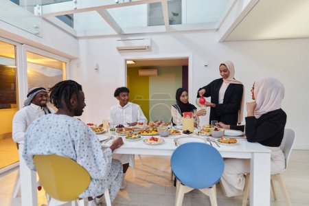 Téléchargez les photos : Une famille musulmane traditionnelle et diversifiée se réunit pour partager un délicieux repas iftar pendant le mois sacré du Ramadan, incarnant l'essence de la joie familiale, de la richesse culturelle et de l'unité spirituelle - en image libre de droit