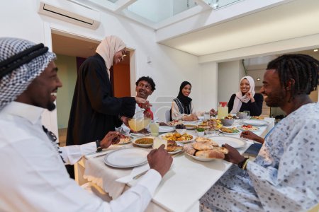 Téléchargez les photos : Au cours du mois sacré du Ramadan, une famille musulmane se réunit joyeusement autour d'une table, attendant avec impatience l'iftar communautaire, s'engageant dans la préparation d'un repas partagé et s'unissant par anticipation - en image libre de droit