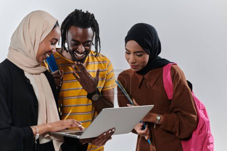Téléchargez les photos : Un groupe d'étudiants, y compris un étudiant afro-américain et deux femmes portant le hijab, se tiennent unis sur un fond blanc immaculé, symbolisant un mélange harmonieux de cultures et de milieux dans - en image libre de droit