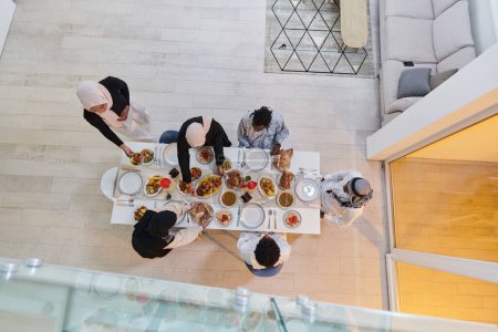 Téléchargez les photos : Vue d'ensemble d'une famille musulmane se réunit joyeusement autour d'une table, attendant avec impatience l'iftar communautaire, s'engageant dans la préparation d'un repas partagé, et s'unissant en prévision d'un collectif - en image libre de droit