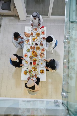 Foto de Vista superior de la familia musulmana tradicional y diversa se reúne para compartir una deliciosa comida de iftar durante el mes sagrado del Ramadán, que encarna la esencia de la alegría familiar, la riqueza cultural, y - Imagen libre de derechos