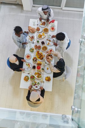 Téléchargez les photos : Vue d'ensemble de la famille musulmane traditionnelle et diversifiée se réunit pour partager un délicieux repas iftar pendant le mois sacré du Ramadan, incarnant l'essence de la joie familiale, la richesse culturelle, et - en image libre de droit