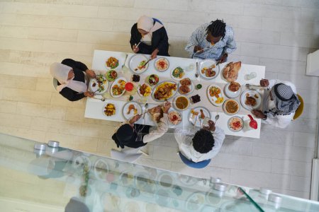 Foto de Vista superior de la familia musulmana tradicional y diversa se reúne para compartir una deliciosa comida de iftar durante el mes sagrado del Ramadán, que encarna la esencia de la alegría familiar, la riqueza cultural, y - Imagen libre de derechos