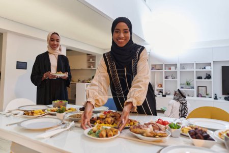 Foto de Grupo de jóvenes árabes se reúnen para preparar amorosamente una mesa de iftar durante el sagrado mes musulmán del Ramadán, encarnando la esencia de la unidad comunitaria, la tradición cultural y la alegría. - Imagen libre de derechos