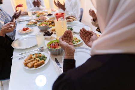 Photo for In the sacred month of Ramadan, a diverse Muslim family comes together in spiritual unity, fervently praying to God before breaking their fast, capturing a moment of collective devotion, cultural - Royalty Free Image