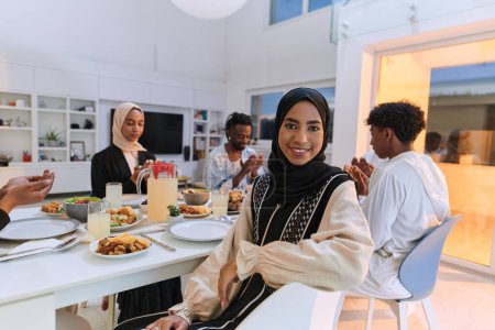 Téléchargez les photos : Dans le mois sacré du Ramadan, une famille musulmane diversifiée se réunit dans l'unité spirituelle, priant avec ferveur Dieu avant de rompre leur jeûne, capturant un moment de dévotion collective, culturelle - en image libre de droit