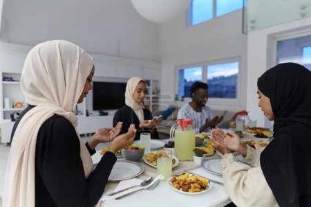 Photo for In the sacred month of Ramadan, a diverse Muslim family comes together in spiritual unity, fervently praying to God before breaking their fast, capturing a moment of collective devotion, cultural - Royalty Free Image
