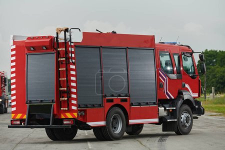 Foto de En esta cautivadora escena, un camión de bomberos de última generación, equipado con tecnología de rescate avanzada, está listo con su experto equipo de bomberos, preparado para intervenir y responder rápidamente a - Imagen libre de derechos