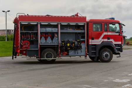 Foto de En esta cautivadora escena, un camión de bomberos de última generación, equipado con tecnología de rescate avanzada, está listo con su experto equipo de bomberos, preparado para intervenir y responder rápidamente a - Imagen libre de derechos