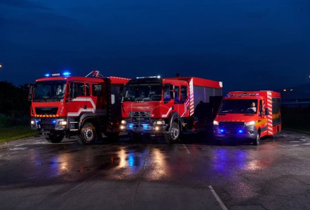 Photo for A pair of highly modern and quality fire trucks illuminate the night with their rotating lights, symbolizing the cutting-edge technology and preparedness of the firefighting fleet, ready to respond to - Royalty Free Image