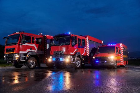 Téléchargez les photos : Une paire de camions de pompiers très modernes et de qualité illuminent la nuit avec leurs lumières tournantes, symbolisant la technologie de pointe et la préparation de la flotte de lutte contre les incendies, prêts à répondre à - en image libre de droit