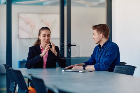 Une dirigeante d'entreprise en costume conversant avec son travailleur dans l'industrie de l'informatique au sujet de nouveaux projets d'entreprise et de problèmes d'entreprise existants. 