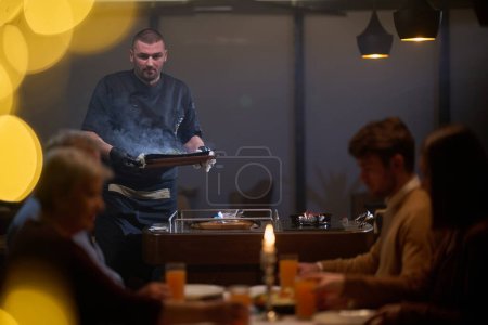 In a restaurant setting, a professional chef presents a sizzling steak cooked over an open flame, while an European Muslim family eagerly awaits their iftar meal during the holy month of Ramadan