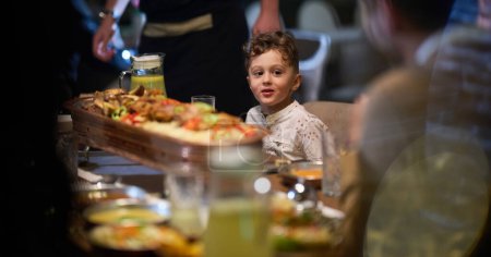 Téléchargez les photos : Dans une scène chaleureuse, un chef professionnel sert à une famille musulmane européenne son repas iftar pendant le mois sacré du Ramadan, incarnant l'unité culturelle et l'hospitalité culinaire dans un moment de partage - en image libre de droit