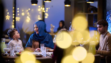 Photo for In a modern restaurant, an Islamic couple and their children joyfully await their iftar meal during the holy month of Ramadan, embodying familial harmony and cultural celebration amidst the - Royalty Free Image