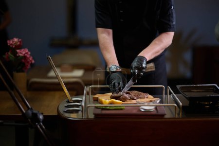 Close-up shot, a professional chef expertly prepares a delicious steak using modern cooking techniques, showcasing culinary excellence and precision in the art of gourmet cuisine.