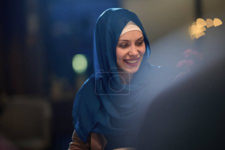 In a modern restaurant, a beautiful European Muslim woman gracefully enjoys the ambiance and culinary delights during the holy month of Ramadan, embodying elegance and spiritual serenity amidst