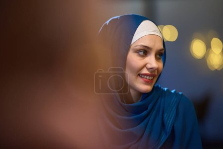 Photo for In a modern restaurant, a beautiful European Muslim woman gracefully enjoys the ambiance and culinary delights during the holy month of Ramadan, embodying elegance and spiritual serenity amidst - Royalty Free Image