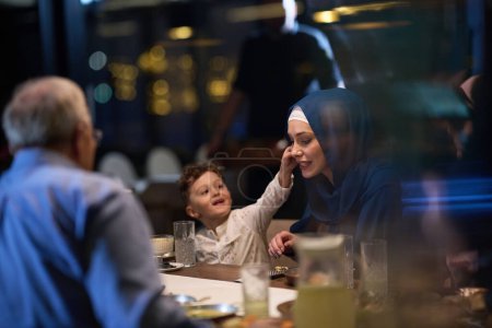 In einer herzerwärmenden Szene lassen sich eine glückliche islamische europäische Familie und ein junges Mädchen reizvoll auf ihre Mutter ein, während sie ihrem Iftar-Essen entgegenfiebern und Freude, Liebe und familiäre Bindung ausstrahlen.