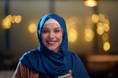 In a modern restaurant, a beautiful European Muslim woman gracefully enjoys the ambiance and culinary delights during the holy month of Ramadan, embodying elegance and spiritual serenity amidst